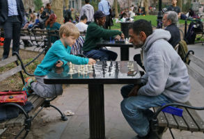 A Kid Playing Chess Against an Adult In New York