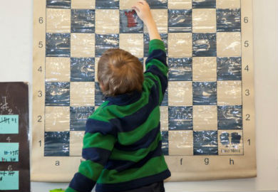 Kid Solving a Chess Problem During a First Move Chess Lesson